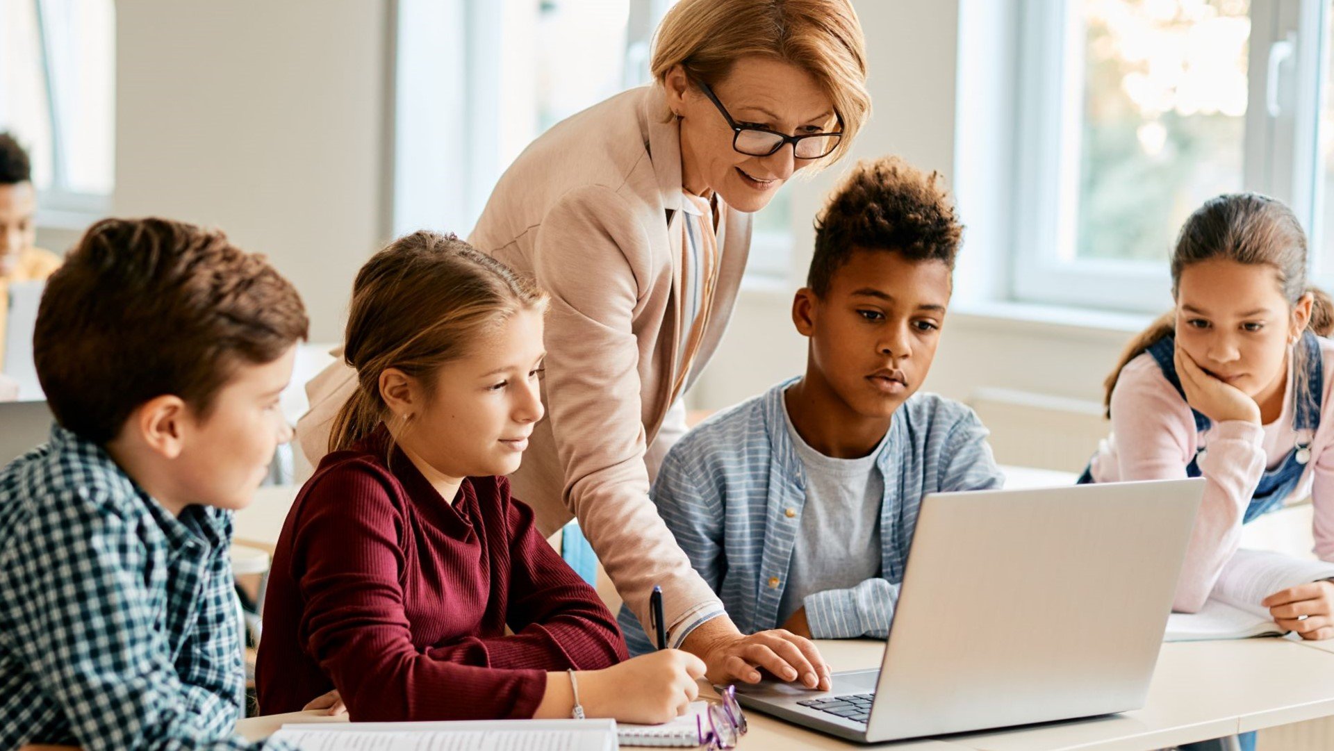 teacher helping students in the classroom