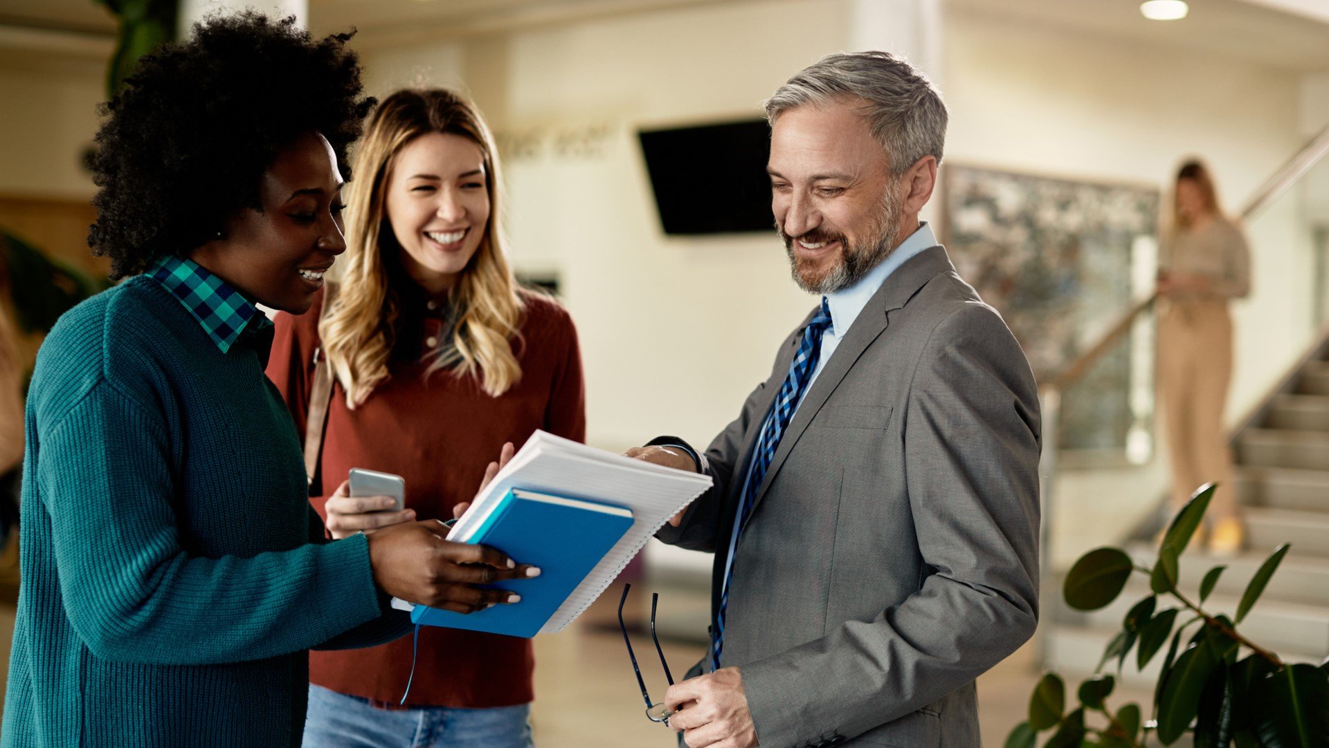 professor chatting with students in hallway